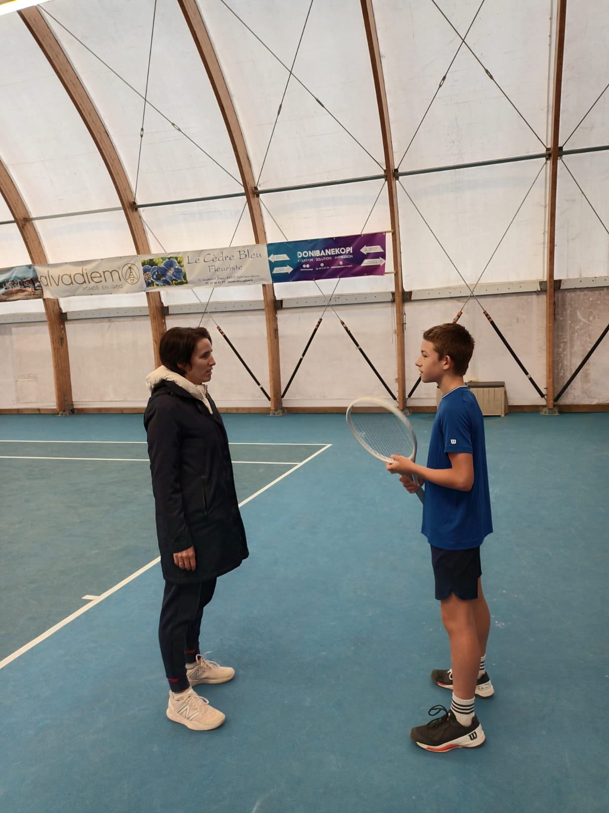 Sylvie en séance de préparation mentale sur un court de tennis indoor avec un jeune joueur